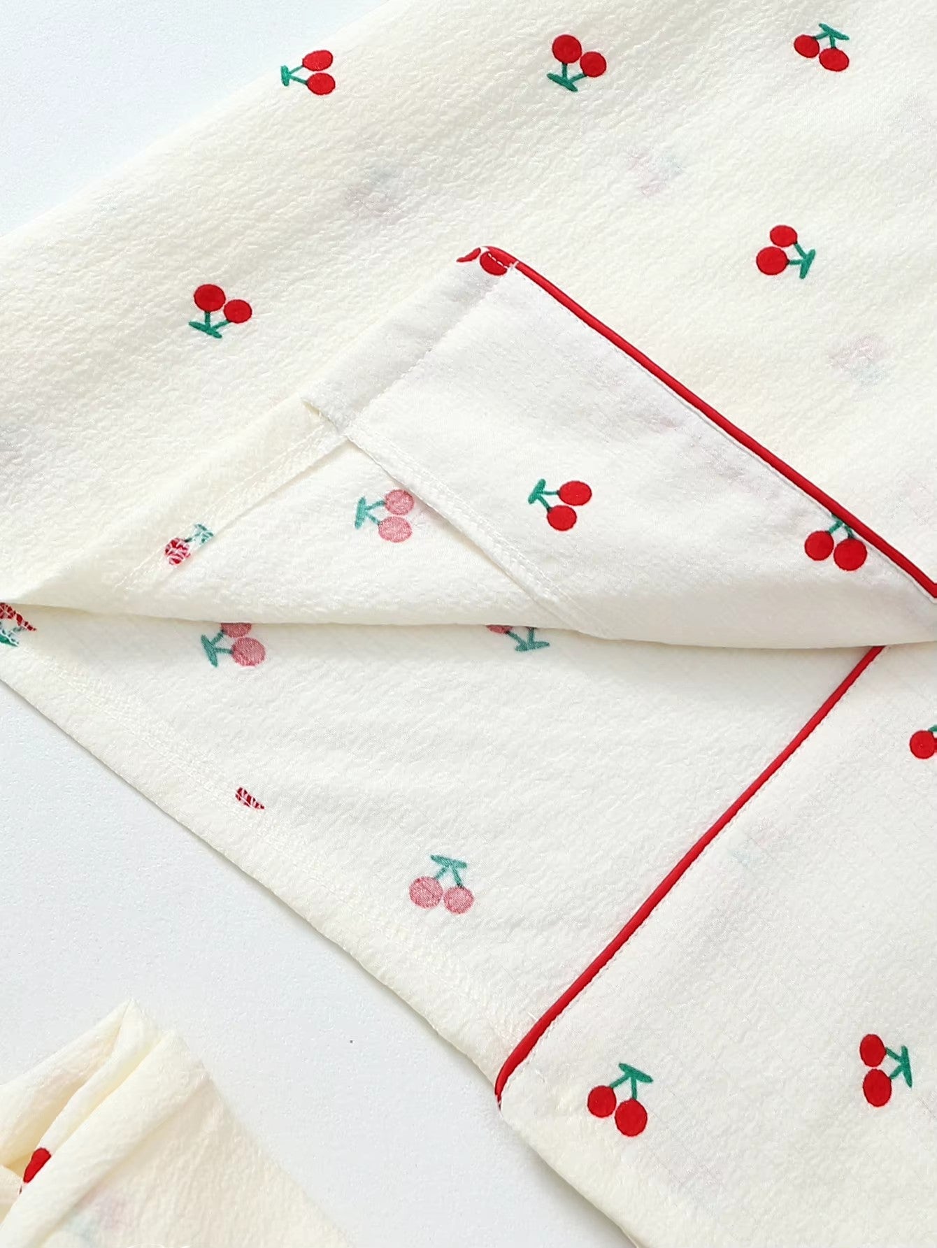Jelly Studio cream lounge shorts with red cherry print and red piping. Lightweight and breathable.