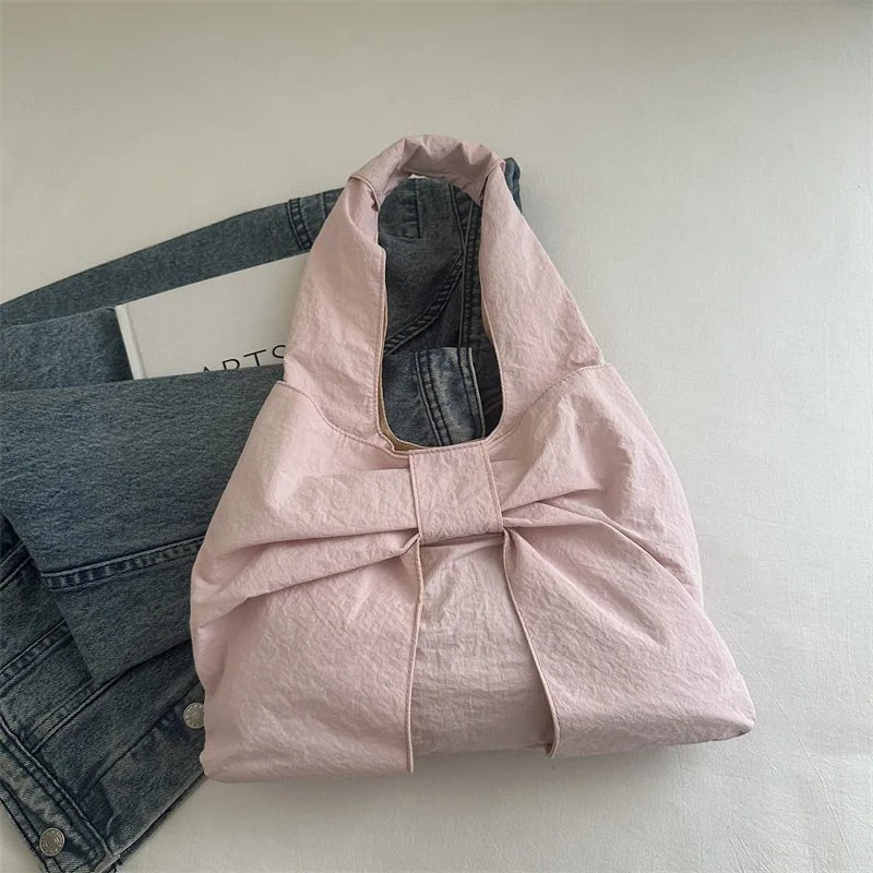 Jelly Studio pink nylon slouchy tote bag with a large bow detail on the front.
