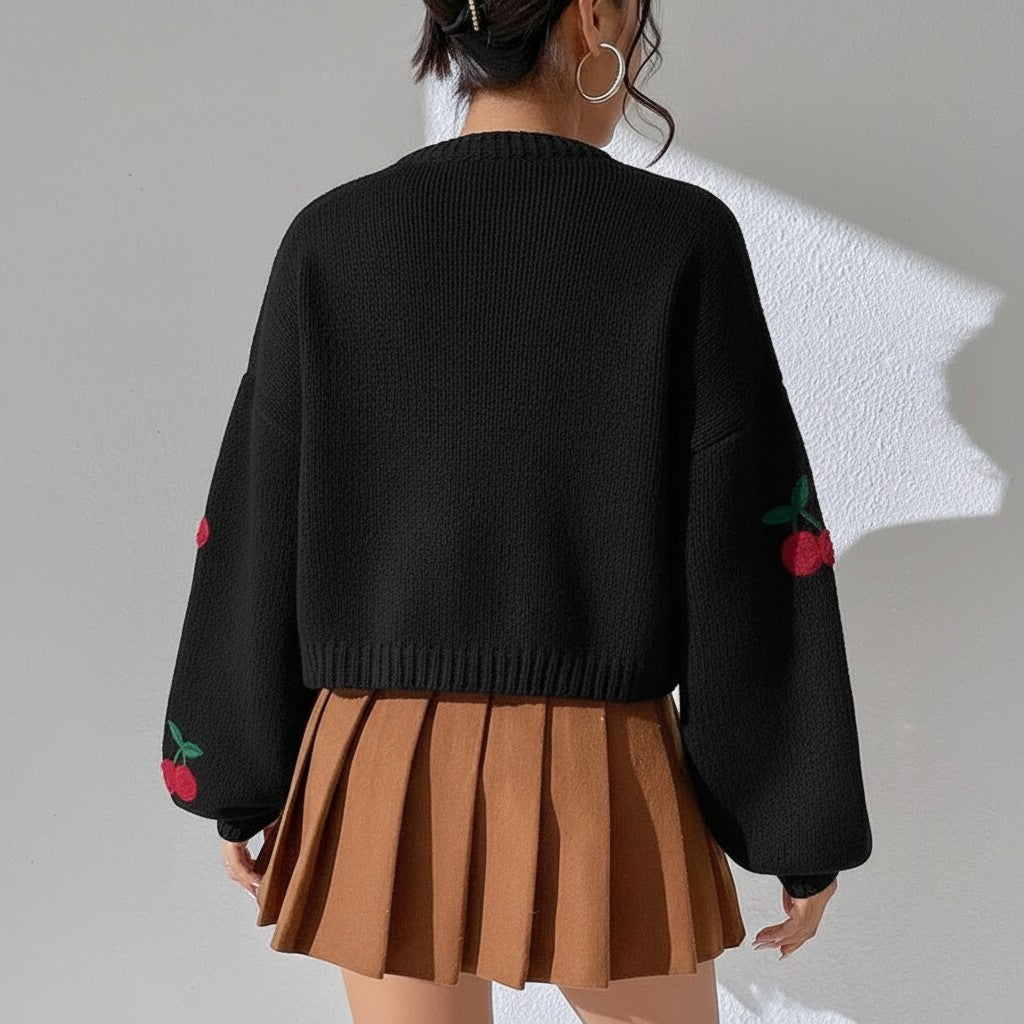 Jelly Studio white knit sweater with cherry embroidery on sleeves, crew neck, and ribbed hem.